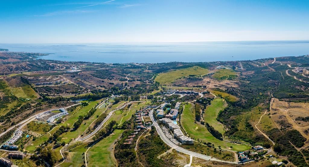 Aerial view of golf fairways and apartments above Estepona with the Mediterranean beyond